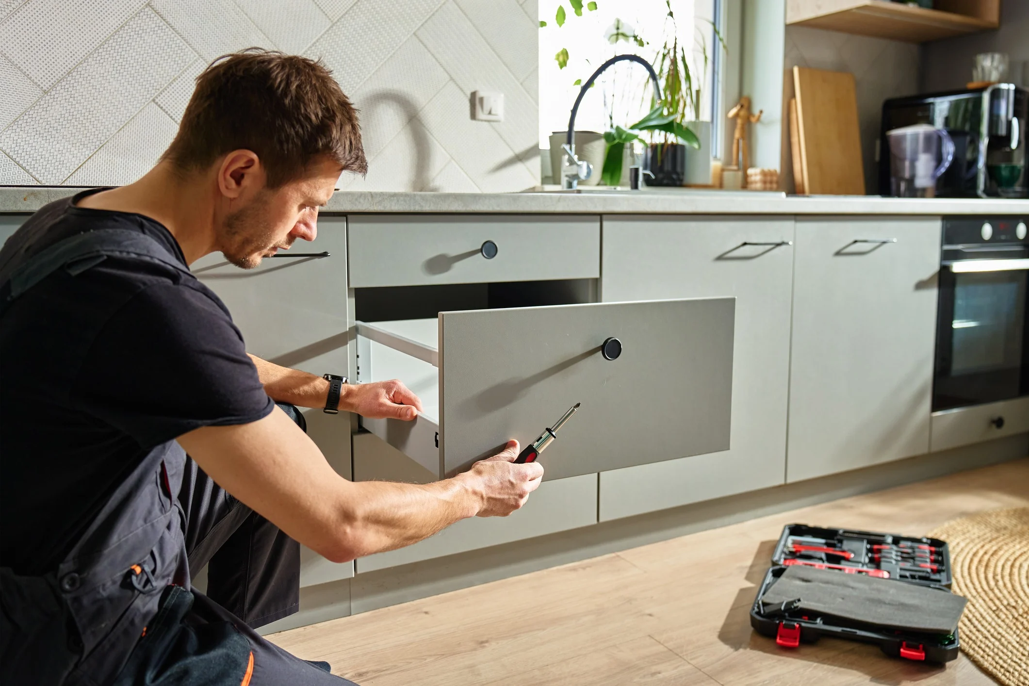 carpenter installing kitchen cabinet drawer
